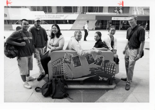 DePaul students take a break from book-buying to enjoy a seat on DePaul's contribution to the city's Suite Home Chicago public art project. Located in the DePaul Center plaza, the couch features images of the Loop and Lincoln Park Campuses, as well as a rendition of an El train that connects them. Photo taken in 2001. (Image courtesy of DePaul University Special Collections and Archives)